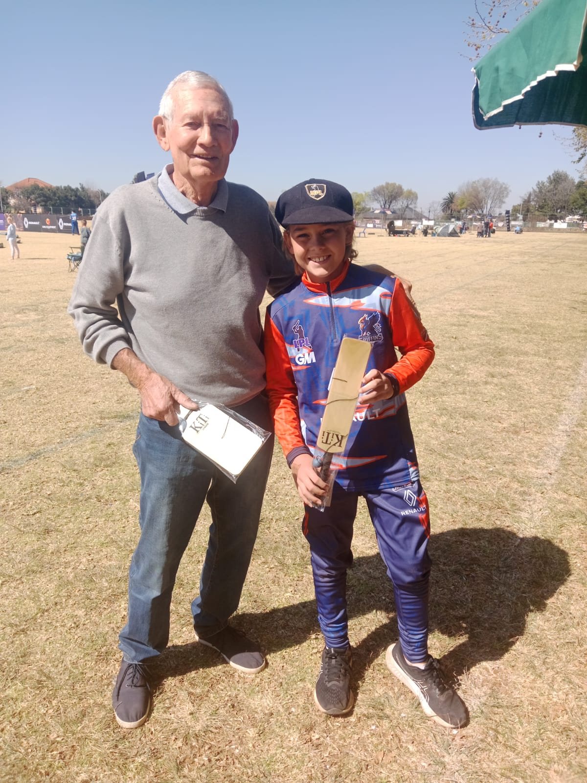 Nico standing with a young cricketer in club colours at a tournament